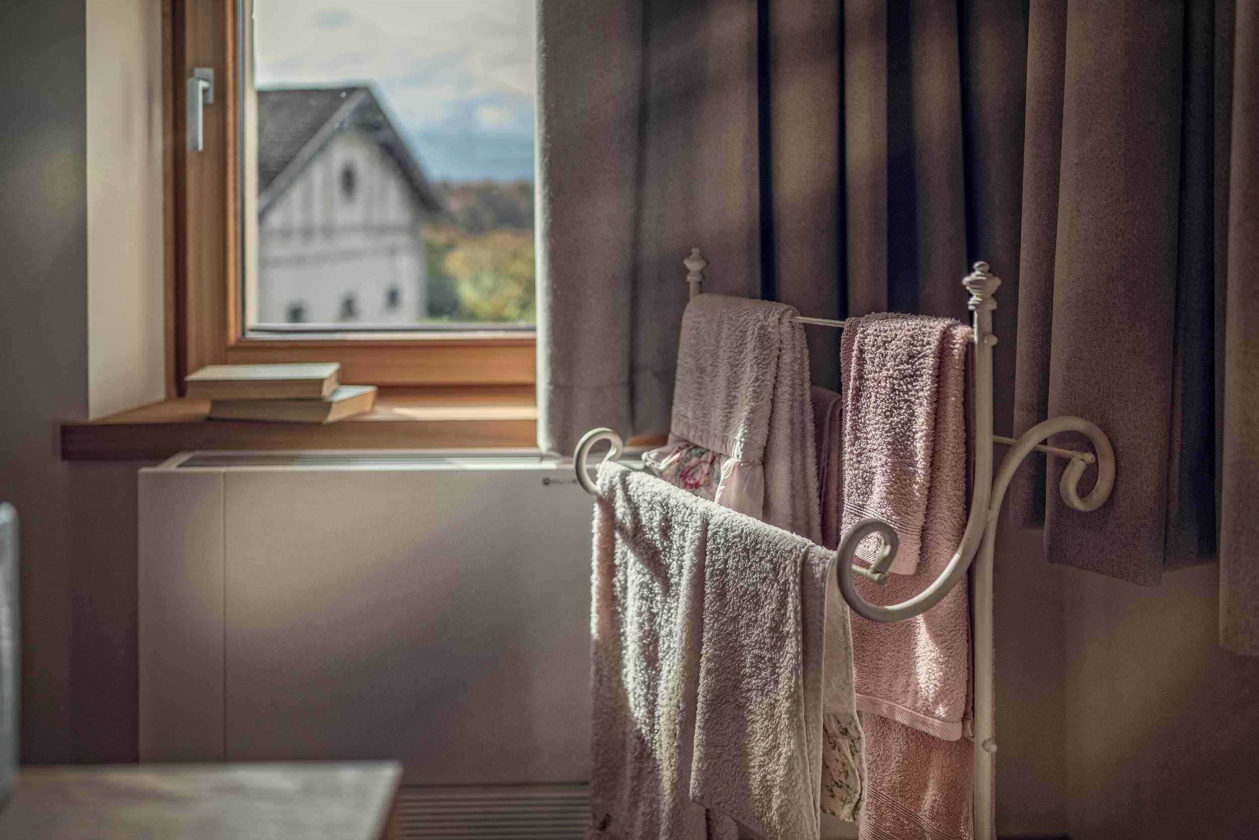 A bedroom with a window, a radiator, and a bed with a headboard.