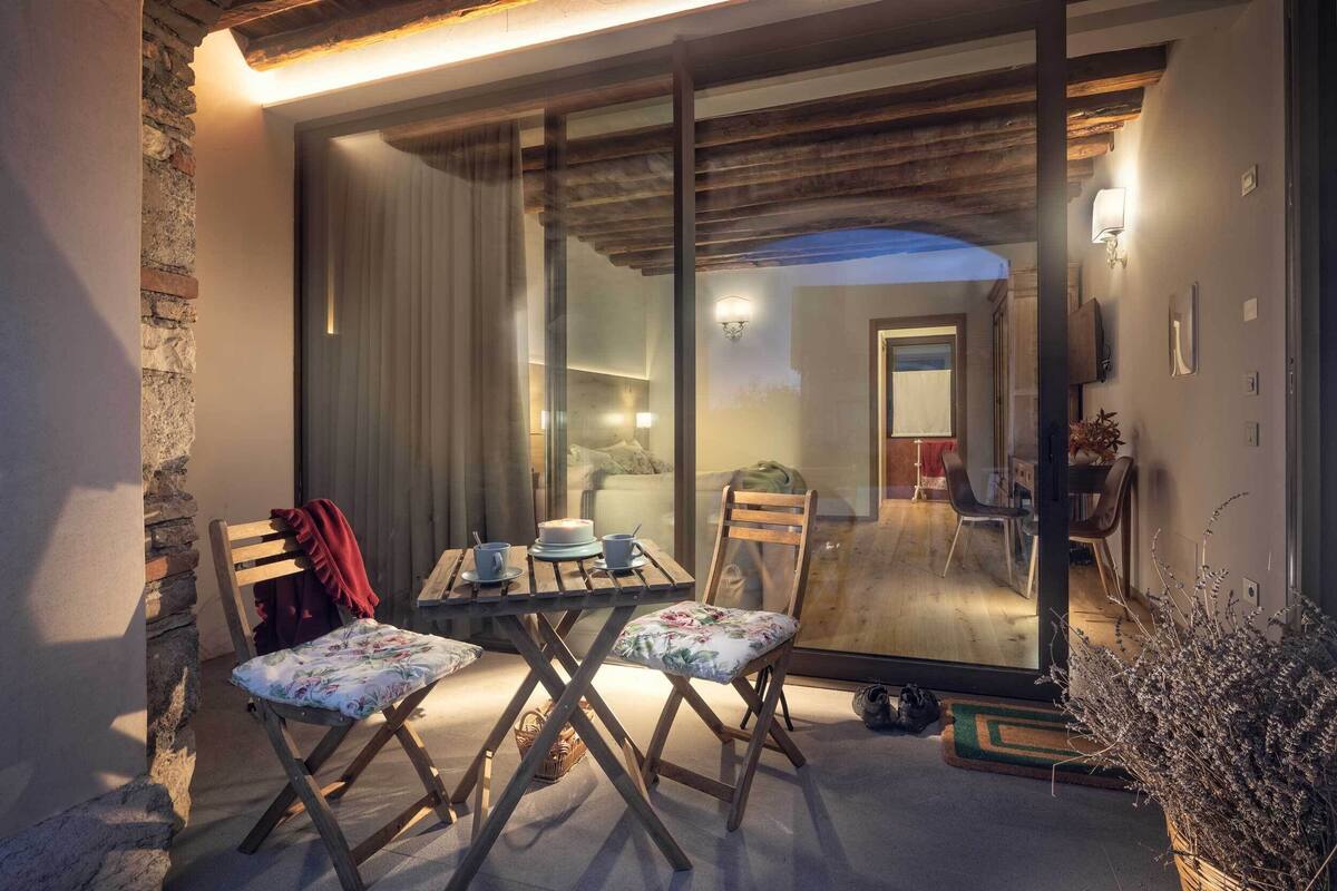 A cozy dining area with a table set for two, a wooden chair, and a bench.