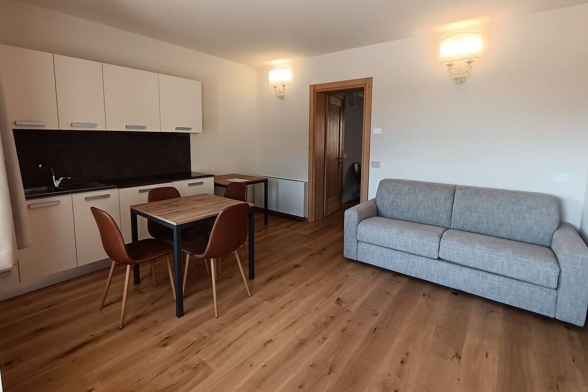 A compact living space with a kitchenette, dining area, and seating.