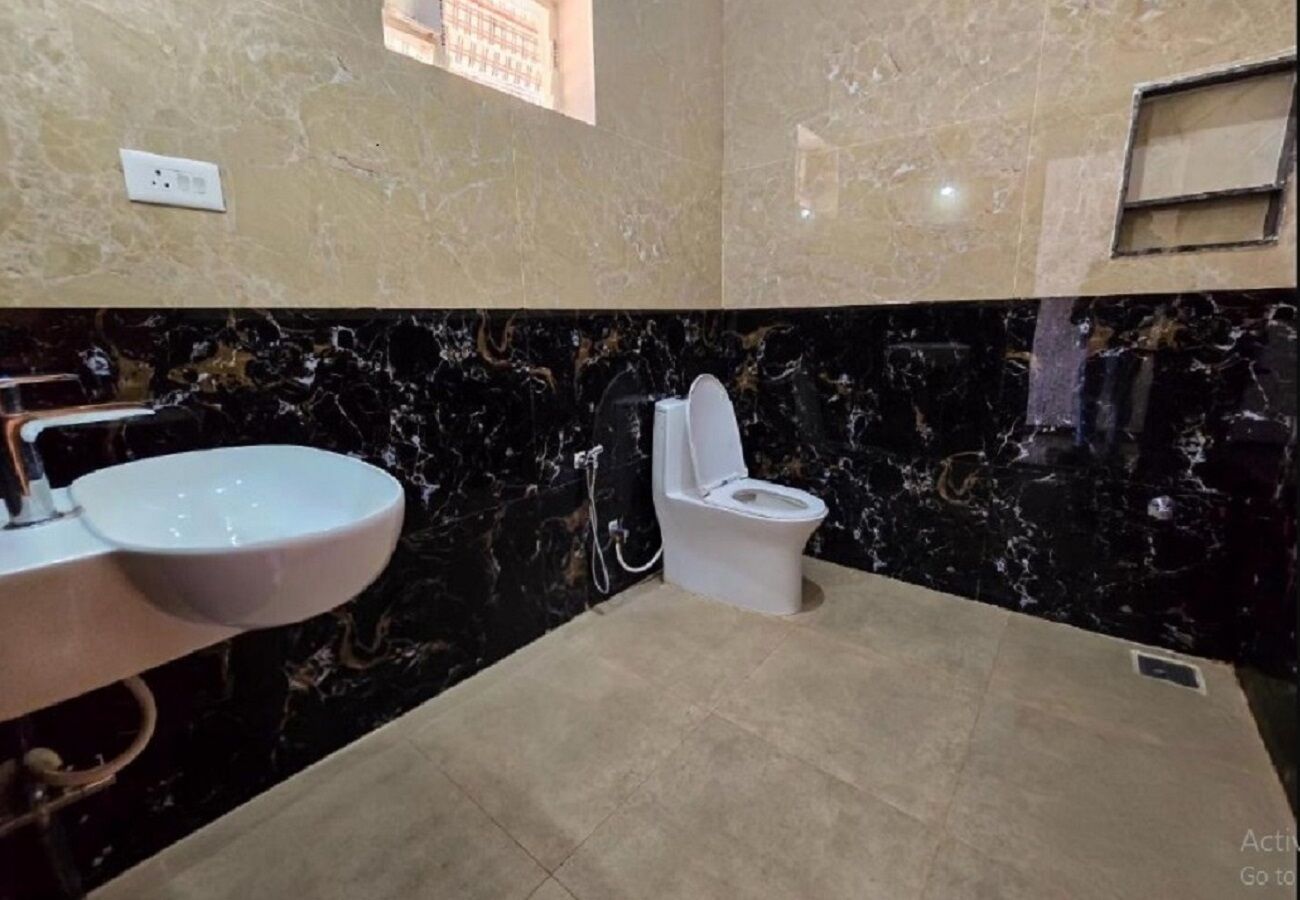 A bathroom with a marble sink, toilet, and floor.