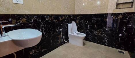 A bathroom with a marble sink, toilet, and floor.