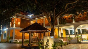 A multi-story hotel with a courtyard, a gazebo, and a Buddha statue. - DE ASIAN RESORT (Vanur)