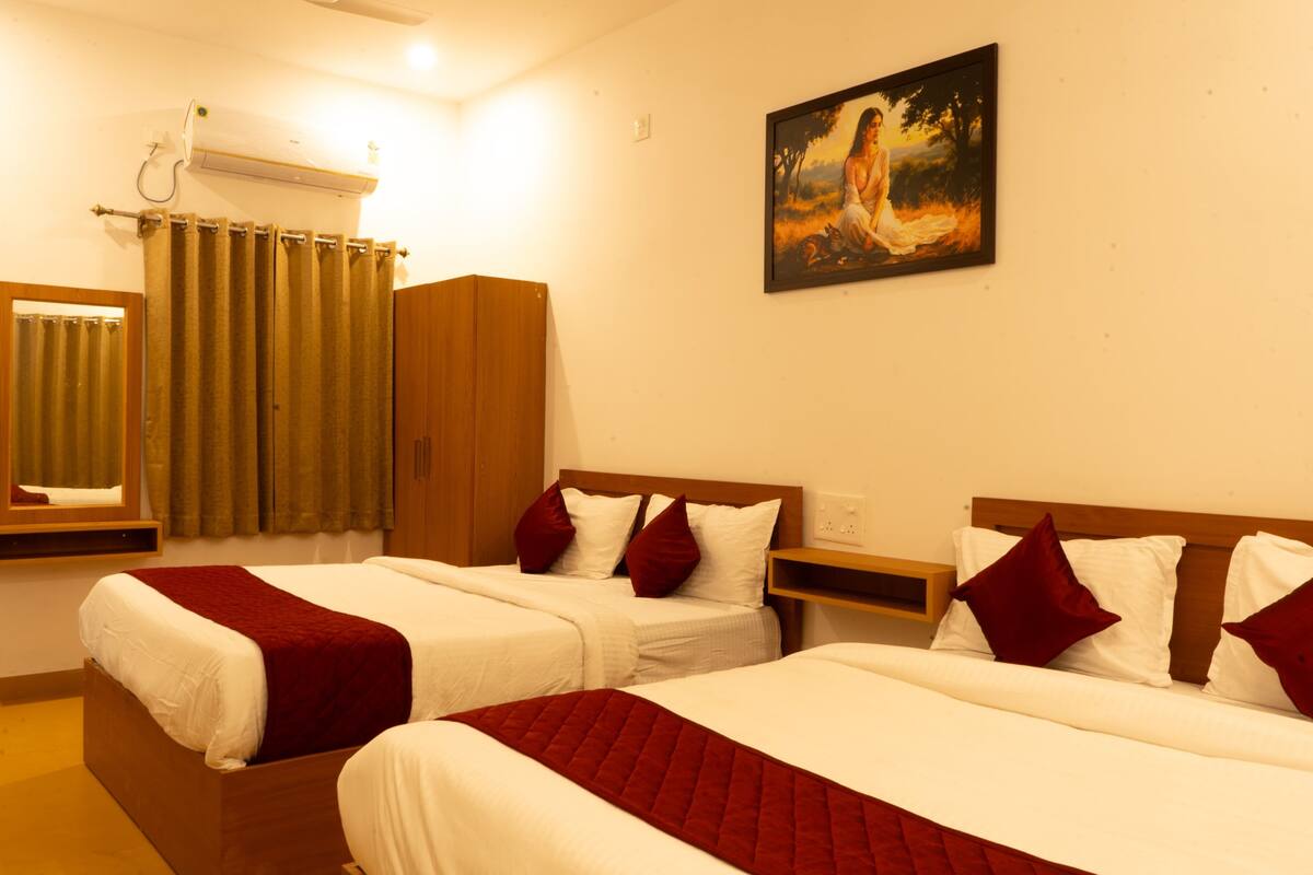 A hotel room with two beds, a painting on the wall, and a window with curtains.