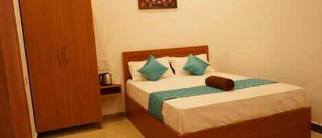 A bedroom with a wooden bed, a nightstand, a wardrobe, and a painting on the wall.