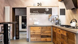 A modern kitchen with wooden cabinets, a gas stove, and a white countertop. - Nice apartment for 4 guests with WIFI, A/C, pool, TV, terrace, pets allowed and panoramic view (Penna)