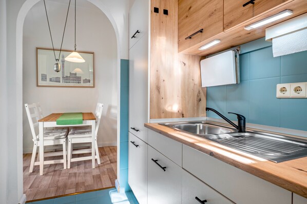 A modern kitchen with a built-in sink, wooden cabinets, and a dining area with a table and chairs.