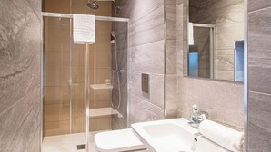 A modern bathroom with a walk-in shower, a sink, and a mirror. - 2 Bedroom City Apartment (Sheffield)