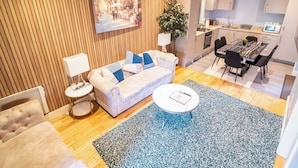 A modern living room with a sofa, a coffee table, and a dining area with a table and chairs. - 2 Bedroom City Apartment (Sheffield)