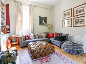 A cozy living room with a sectional sofa, a tufted ottoman, a bean bag, and a fireplace. - The Granary (Southampton)