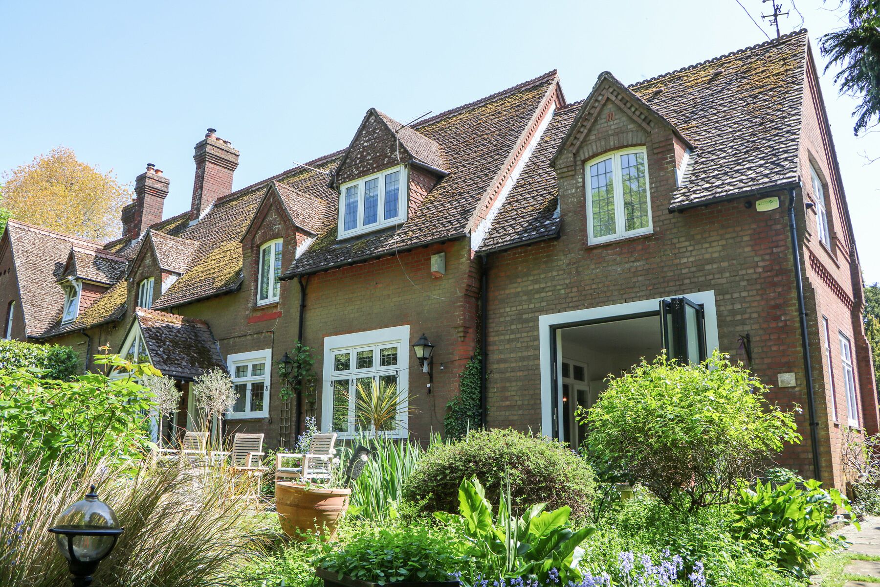 A row of traditional brick houses with pitched roofs and multiple chimneys.
