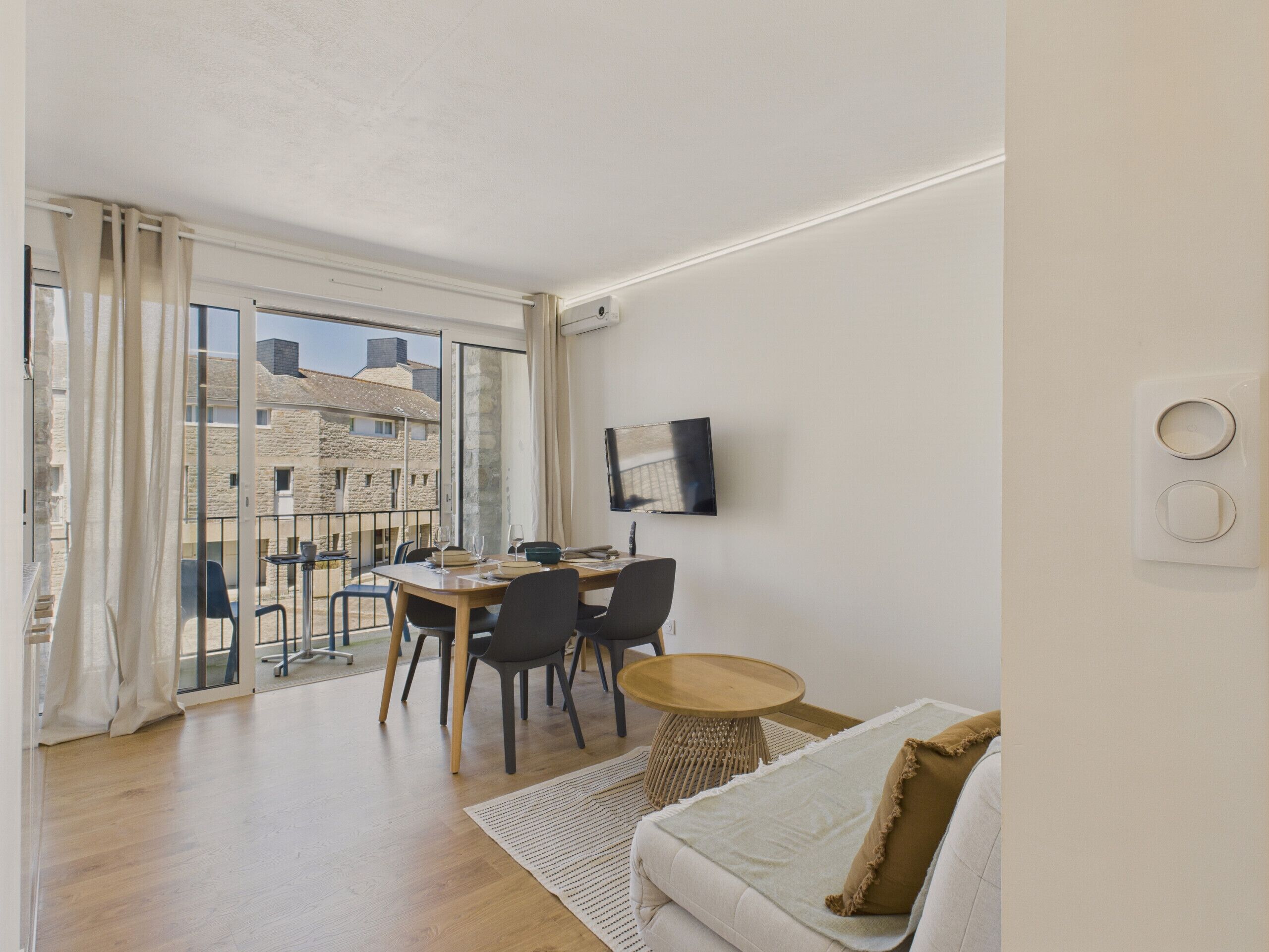 A modern apartment with a balcony, a dining area, and a living space.