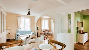 Un coin repas avec une table dressée pour quatre personnes, un canapé et une table à manger avec des chaises.