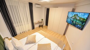 Une chambre à coucher moderne avec un lit, un bureau et un téléviseur.