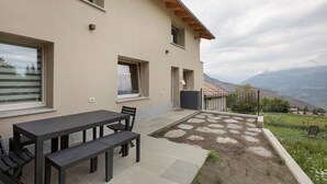 A house with a patio, a table, and chairs.