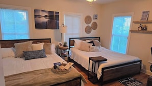 A bedroom with two beds, a ceiling fan, and a view of the river. - Downtown Riverside Lighthouse (New Bern)