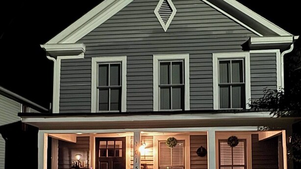 A two-story house with a front porch, a staircase, and a mailbox. - Downtown Riverside Lighthouse (New Bern)