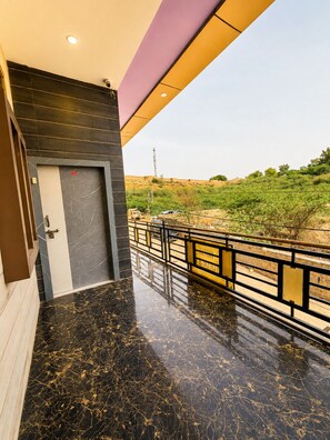 A modern building with a marble floor, a door with a number, and a view of a green landscape. - Hotel The Vintage Villa Jaisalmer (Jaisalmer)