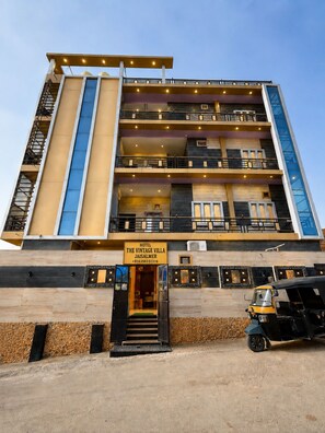 A multi-story hotel with a modern design, featuring balconies, a prominent entrance, and a sign indicating it is 'The Vintage Villa Jaisalmer.'