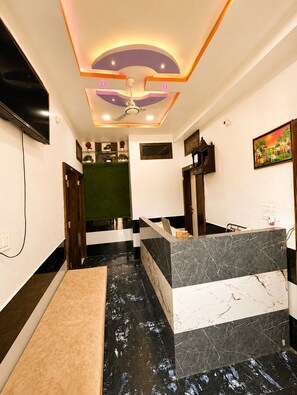 A reception area with a marble counter, a ceiling fan, and a television mounted on the wall. - Hotel The Vintage Villa Jaisalmer (Jaisalmer)
