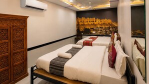 Una camera d'albergo moderna con un letto grande, un armadio in legno e un murale raffigurante un panorama urbano.
