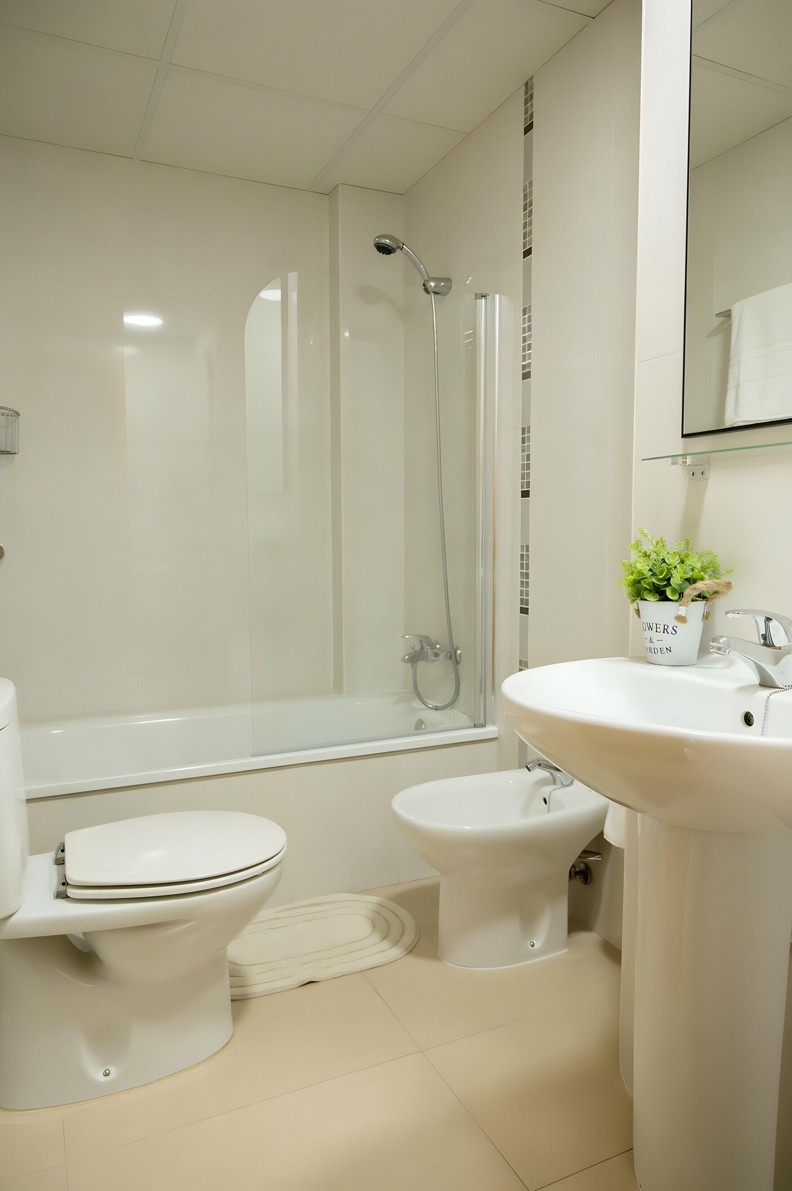 Une salle de bain moderne équipée de toilettes, d’un bidet, d’une baignoire et d’un lavabo.