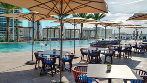 A rooftop pool area with lounge chairs, umbrellas, and tables. - 1BR Beach Condo | Sea View | Hollywood Broadwalk (Hollywood)