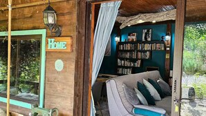 Una habitación acogedora con techo de madera, una estantería y un cartel que dice 'BIBLIOTHEK'.