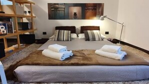 Een keurig opgemaakt slaapkamer met een groot bed, een houten boekenkast en een wereldbol op de plank.