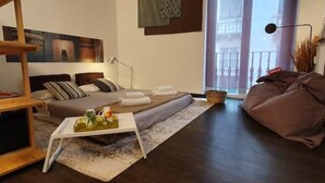 Een moderne woonkamer met een bank, een salontafel en een groot raam met uitzicht op gebouwen.