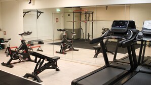 A gym with cardio equipment, including treadmills and stationary bikes, and a weightlifting area with a squat rack. - Allihoop - Bromma Friends (Bromma)