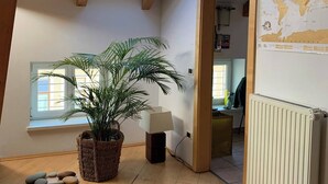 A room with a skylight, a large potted plant, a radiator, and a world map on the wall. - Sunflower House (Bolzano)