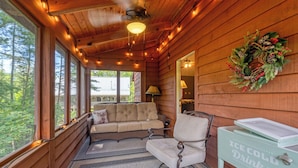 Un interior de cabaña acogedor con un sofá, un sillón y una mesa que dice 'Bebidas HIELO FRÍO'.