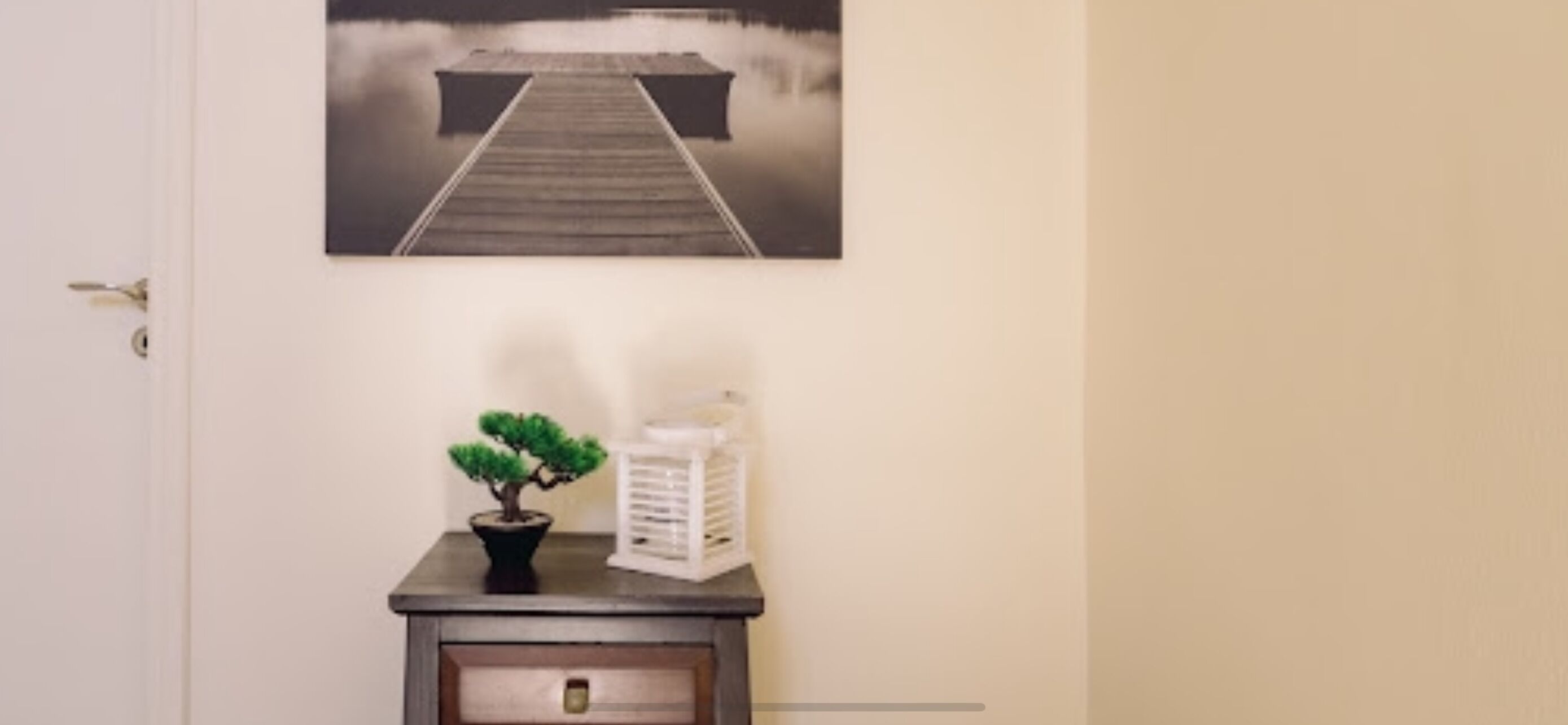 A door with a framed picture of a pier extending into a misty lake.