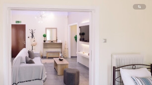 Et moderne hotelværelse med seng, lille sofa, sofabord og spiseplads med bænk.