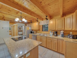 A spacious kitchen with granite countertops, wooden cabinets, and a central island. - Cabin w/Great View|Hot Tub|Pool Table & Air Hockey (Gatlinburg)