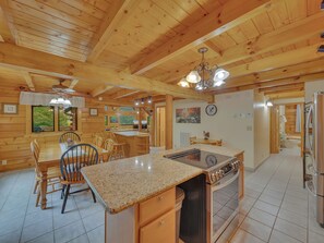 Interior de una cabaña de madera con cocina, comedor y baño.