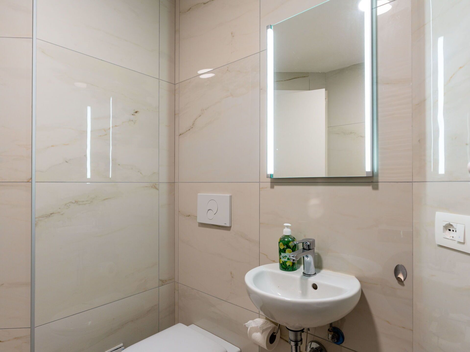 Ein Badezimmer mit Waschbecken, Spiegel und Toilette.
