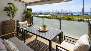 Ein Balkon mit Tisch, Stühlen und Topfpflanzen.