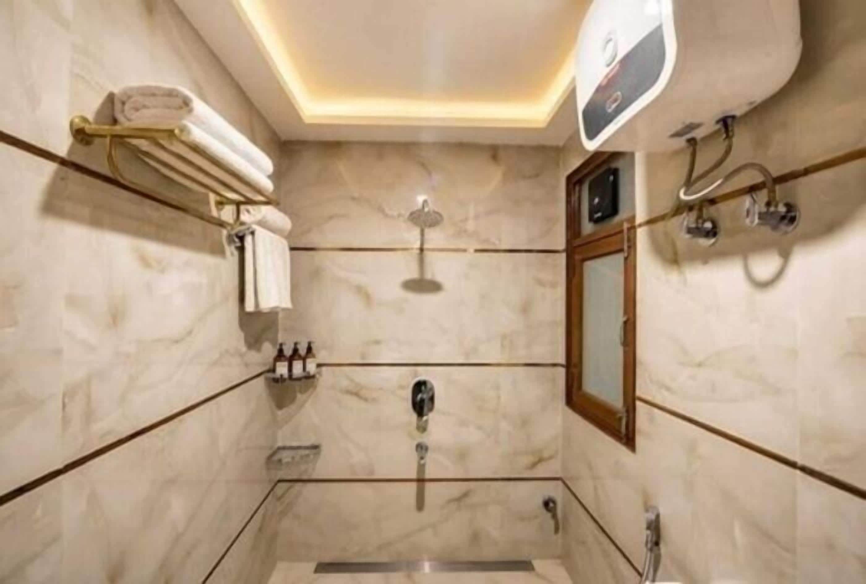 A modern bathroom with a marble floor, a glass-enclosed shower, a vanity with a mirror, and a towel rack.