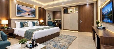 A modern hotel room with a large bed, a desk, a TV, and a wardrobe.