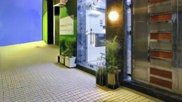 A hotel entrance with a sign reading 'Dream World,' a glass door, and potted plants.