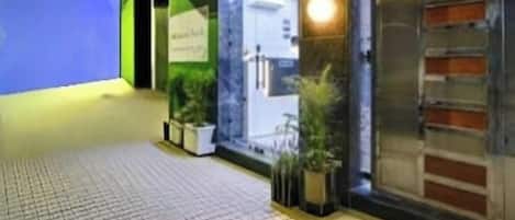 A hotel entrance with a sign reading 'Dream World,' a glass door, and potted plants.