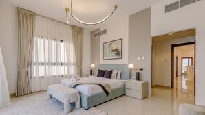 A modern bedroom with a large bed, bedside tables, a nightstand, a headboard, a window with curtains, and a painting on the wall. - Sea Views & Private Pool, Near Beaches & Attractions – Sharm Al Dana (Fujairah)