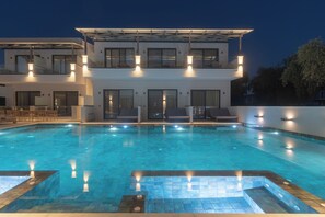A modern hotel with a swimming pool, outdoor seating, and a two-story structure. - Alora Luxury Suites (Thasos)