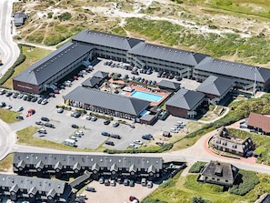 An aerial view of a hotel with multiple buildings, a swimming pool, and a parking lot. - 4 Person Holiday Home on a Holiday Park in Fano (Fano)