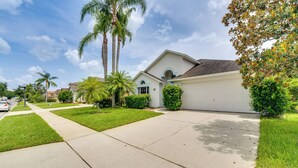 Una casa suburbana con garaje, entrada para vehículos y césped cuidado.