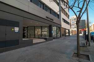 Un bâtiment moderne avec une devanture portant l’inscription « FLIPCO RETRO » et un arbre au premier plan.