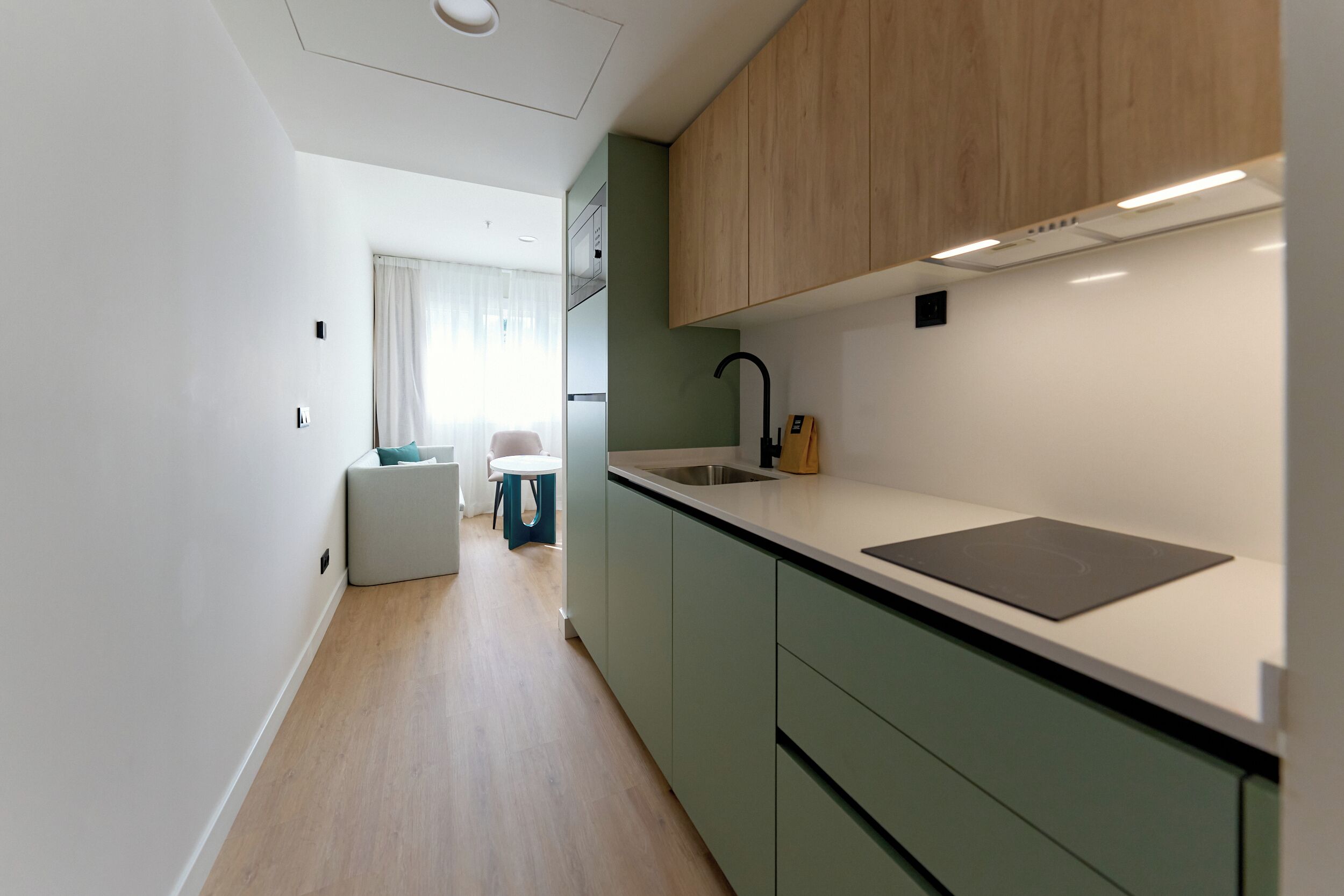 A modern kitchen with a built-in stove, a sink, and wooden cabinets.
