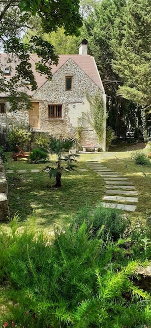 A stone house with a garden pathway leading to a door.