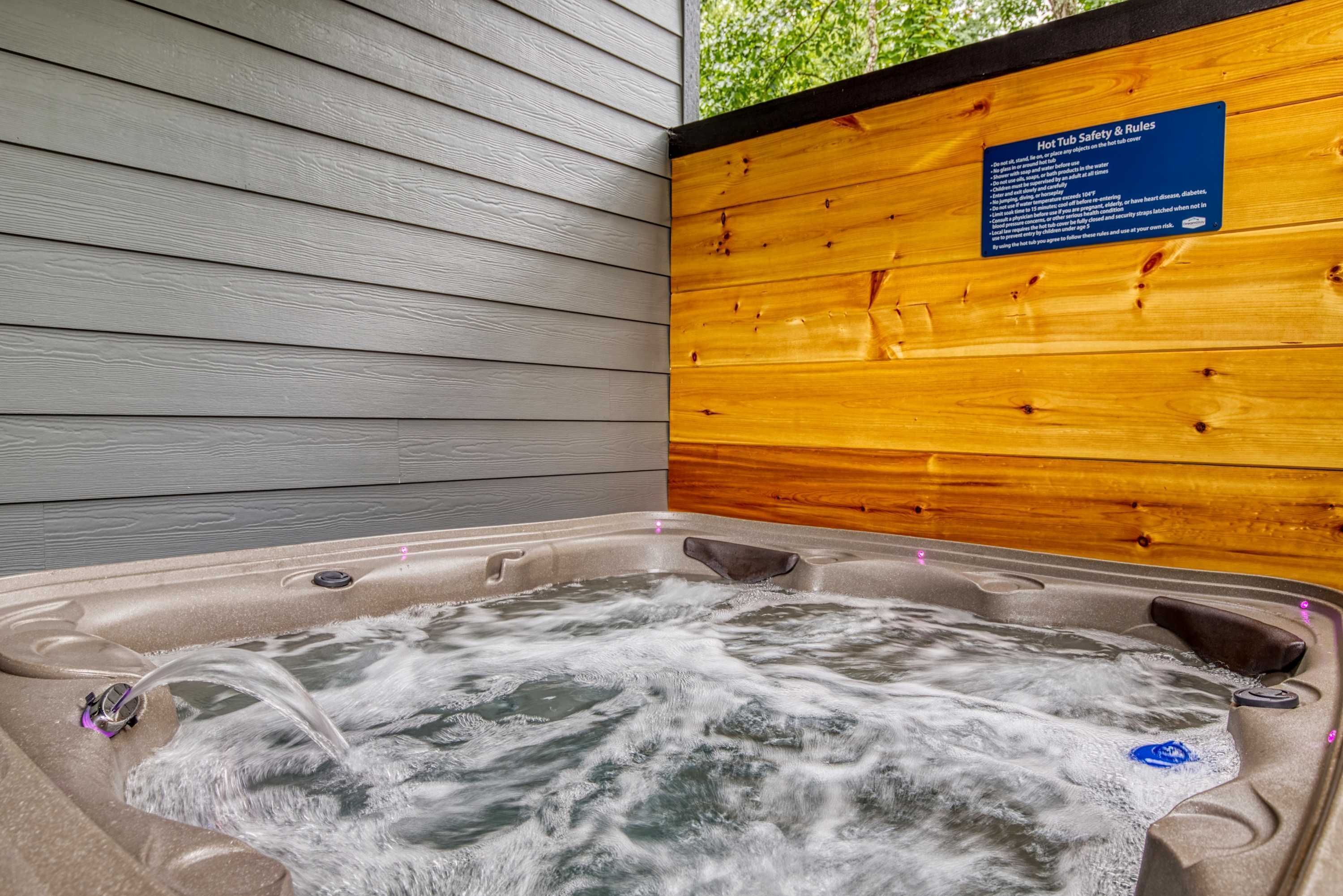 A hot tub with flowing water, surrounded by wooden walls and a wooden ceiling.